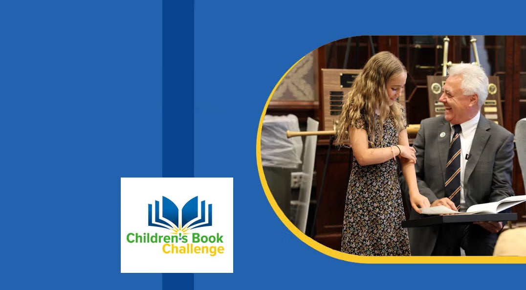 laughing man kneeling next to smiling girl looking at book