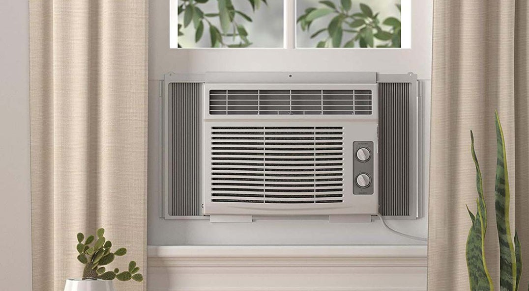 air conditioner unit in a window with white curtains