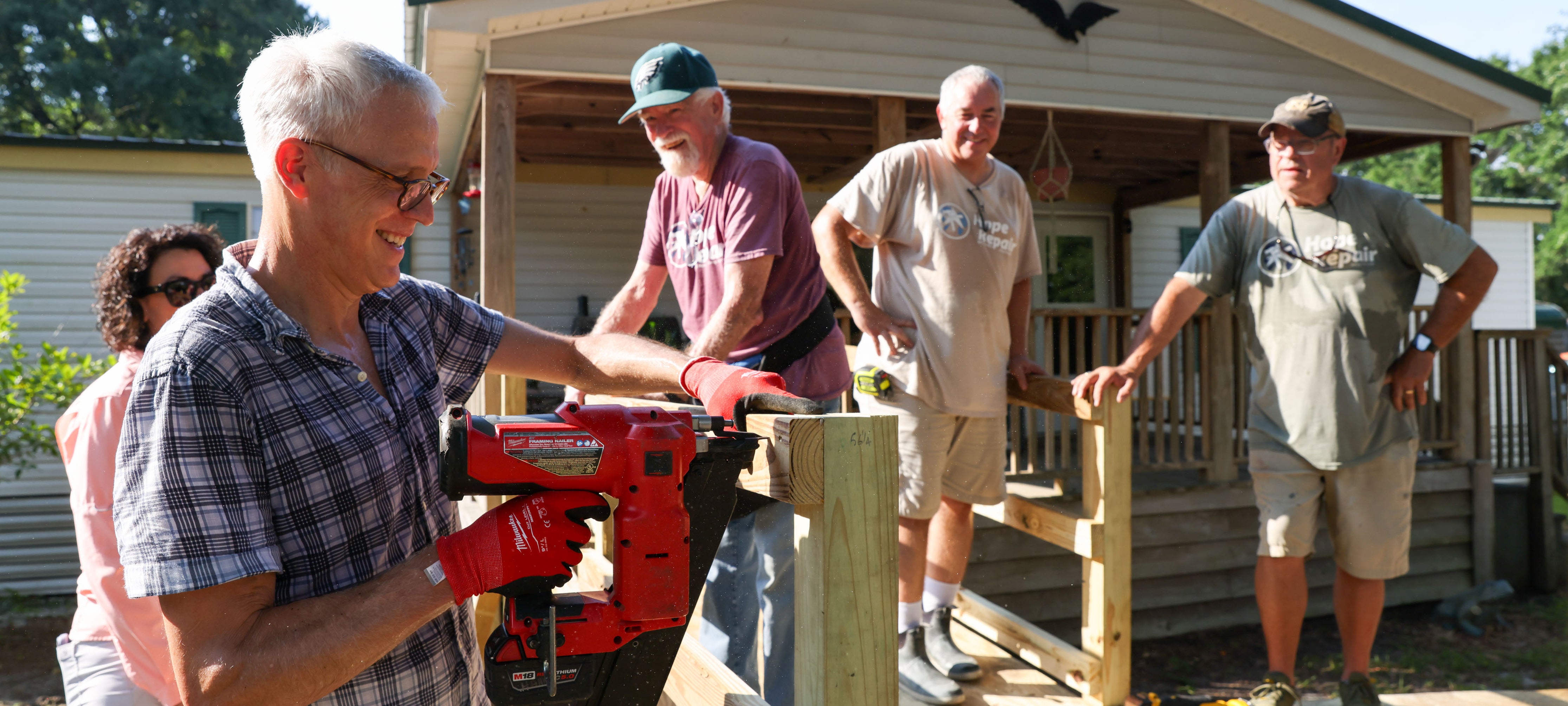 man using nail gun to build wheelchair ramp