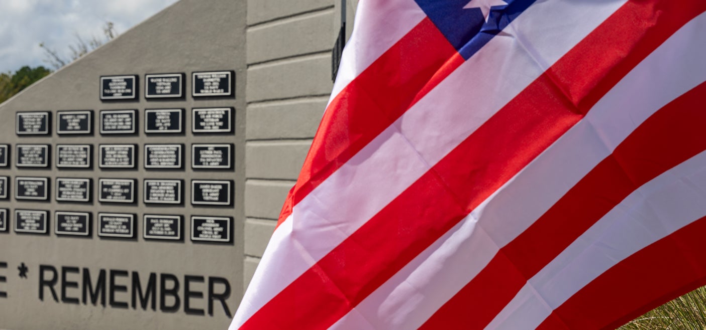 American flag waving in front of veterans memorial
